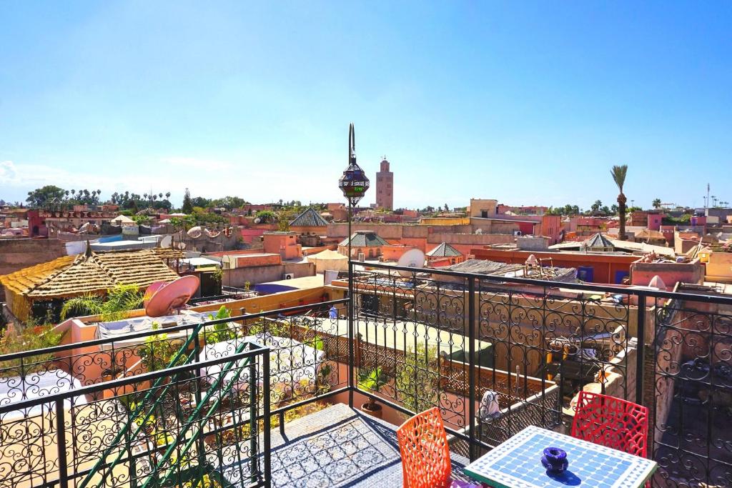 balcón con mesa, sillas y ciudad en Riad Layla Rouge, en Marrakech