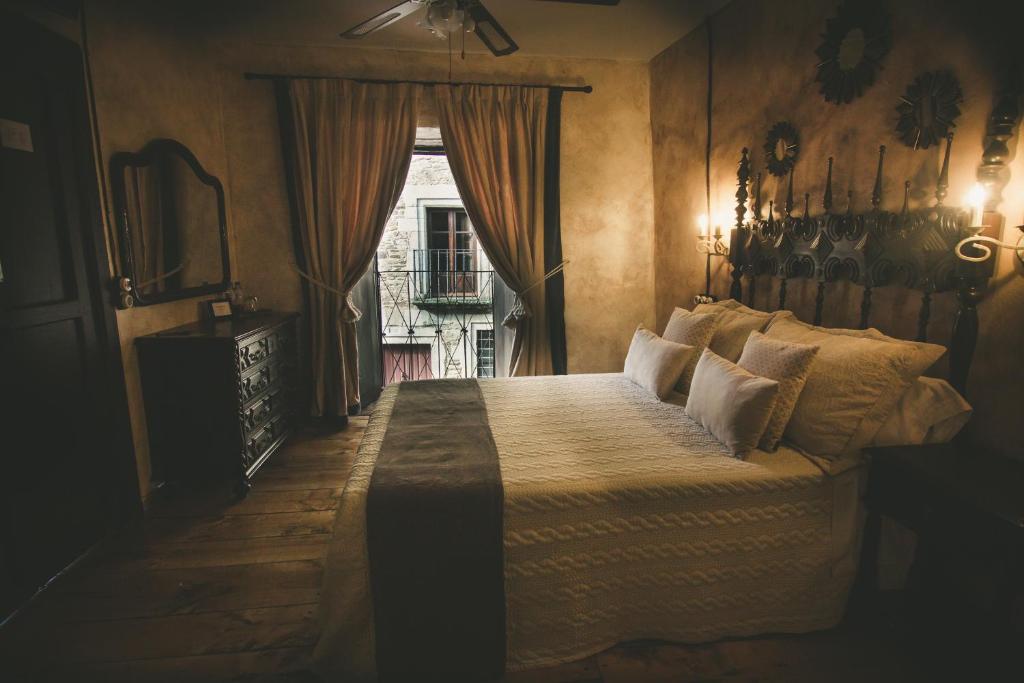 Un dormitorio con una cama grande y una ventana en Hotel Rural La Guaja, en Puebla de Sanabria