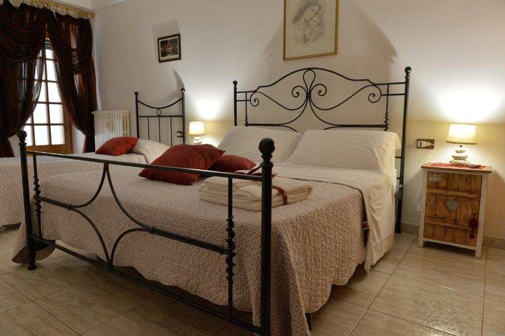 アルベロベッロにあるDimora Carmineのベッドルーム1室(白いシーツと赤い枕のベッド1台付)