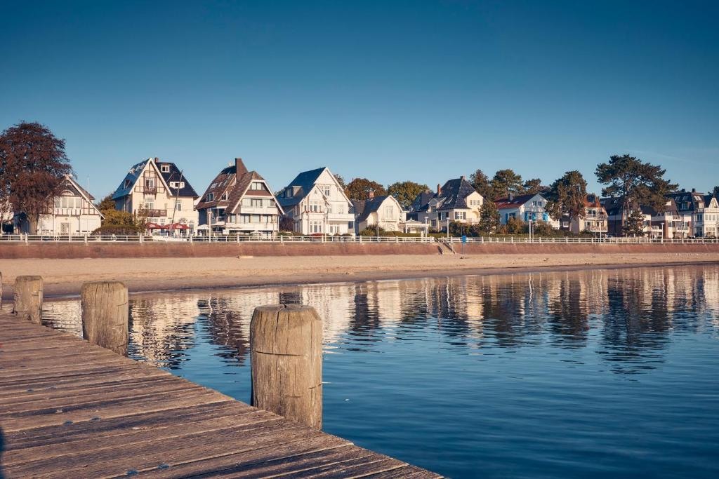 a group of houses on the shore of a body of water at Strandperle Lieblingsplatz Hotel in Travemünde