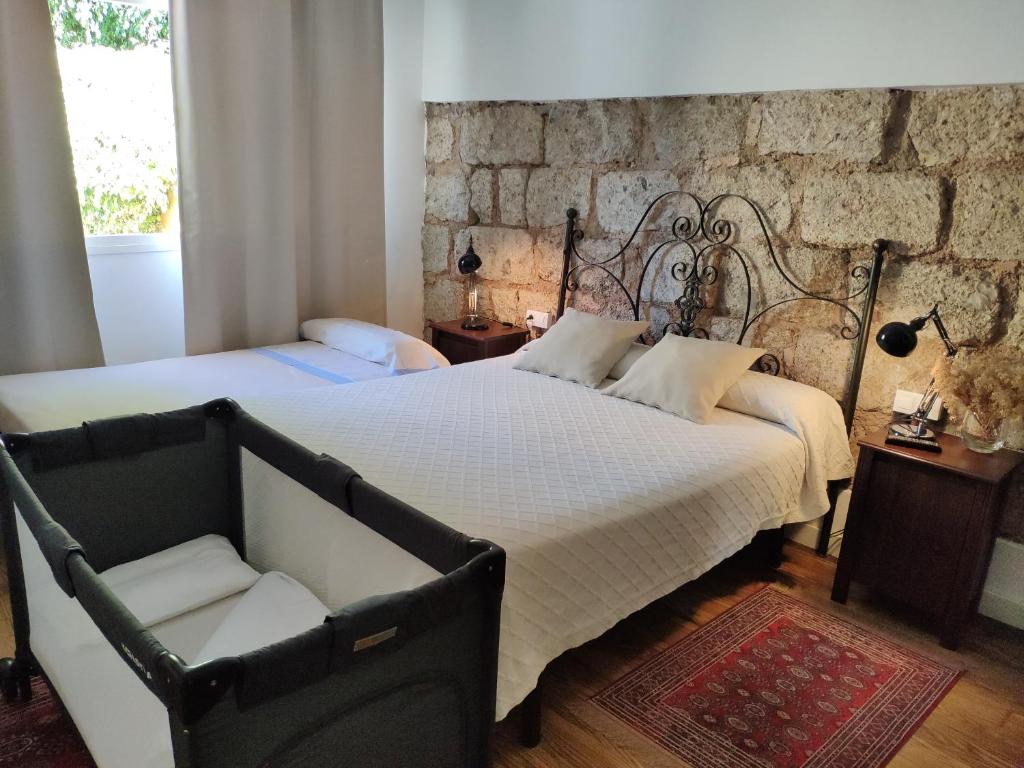 a bedroom with two beds and a chair at Finca El Trazo in Tacoronte