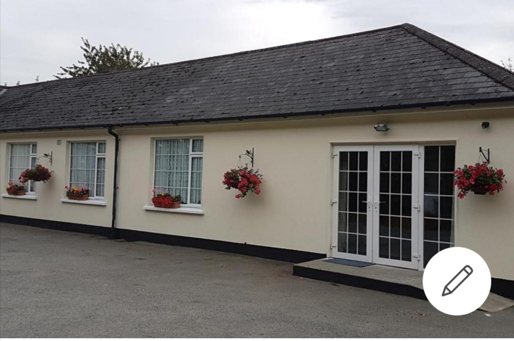 a white house with flowers on the windows and a magnifier at Mullaghbeag Lodge in Navan