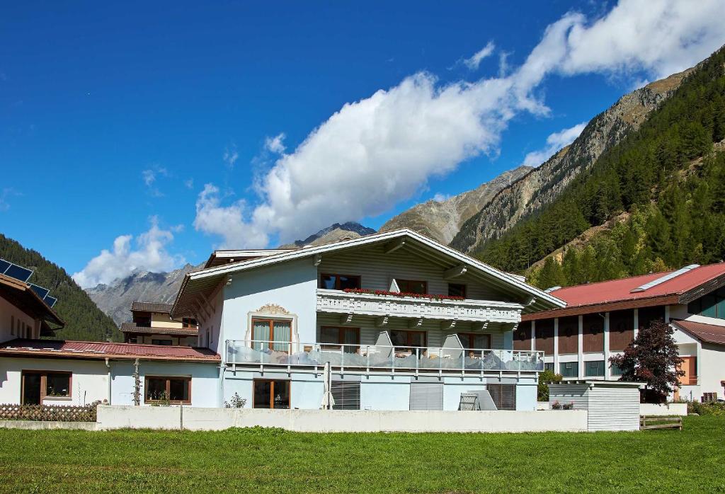 a large white building with mountains in the background at Kristiania in Sölden