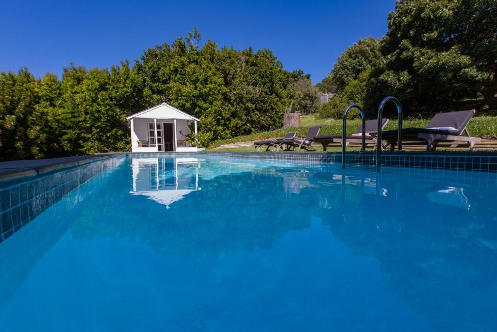 une grande piscine avec un kiosque blanc dans l'établissement Kronendal Heritage, à Hout Bay