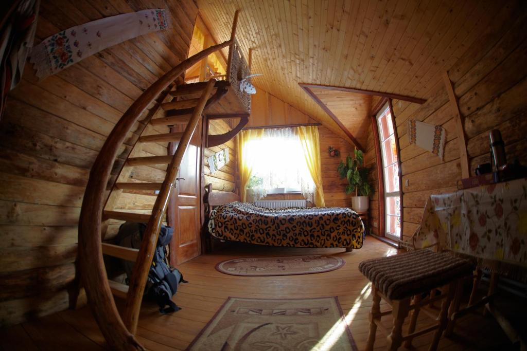 a bedroom with a spiral staircase in a wooden cabin at Cottage 12 Months in Vorokhta