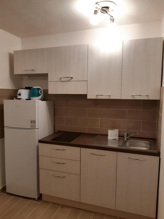 een keuken met witte kasten en een witte koelkast bij Friedrich Apartments in Merano
