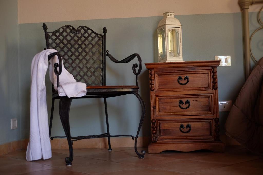 塔爾奎尼亞的住宿－Agriturismo Podere Farnesiana，梳妆台旁边的椅子和梳妆台