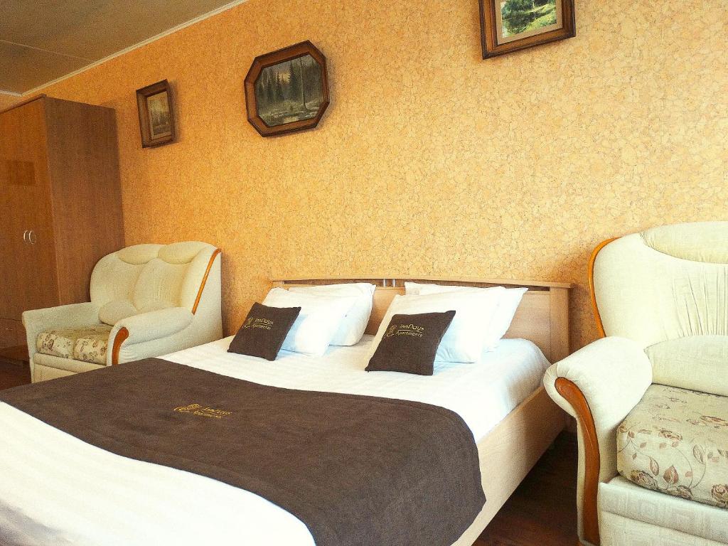 a hotel room with two beds and two chairs at Inndays on 9 Maya in Tula