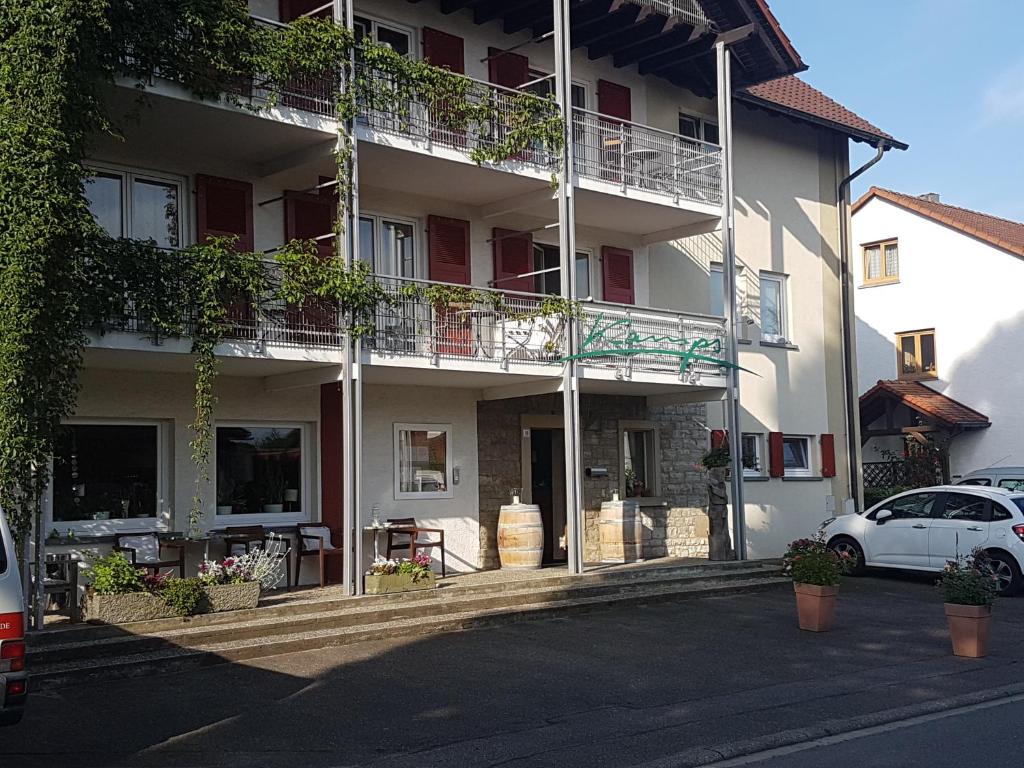 een witte auto geparkeerd voor een gebouw bij Hotel KAMPS in Sinsheim