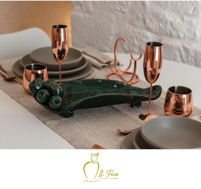 - une table avec deux verres à vin et une pièce maîtresse verte dans l'établissement IL Fico Luxury Home Ostuni, à Ostuni