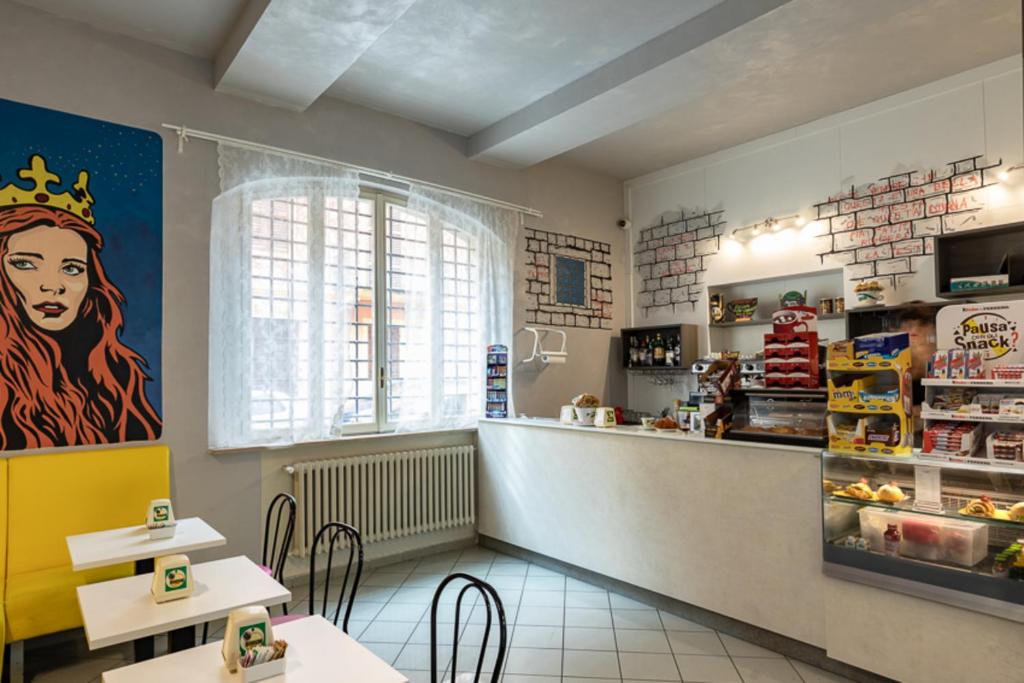 ein Fast-Food-Restaurant mit einer Theke und Tischen in der Unterkunft Ostello San Filippo Neri in Modena