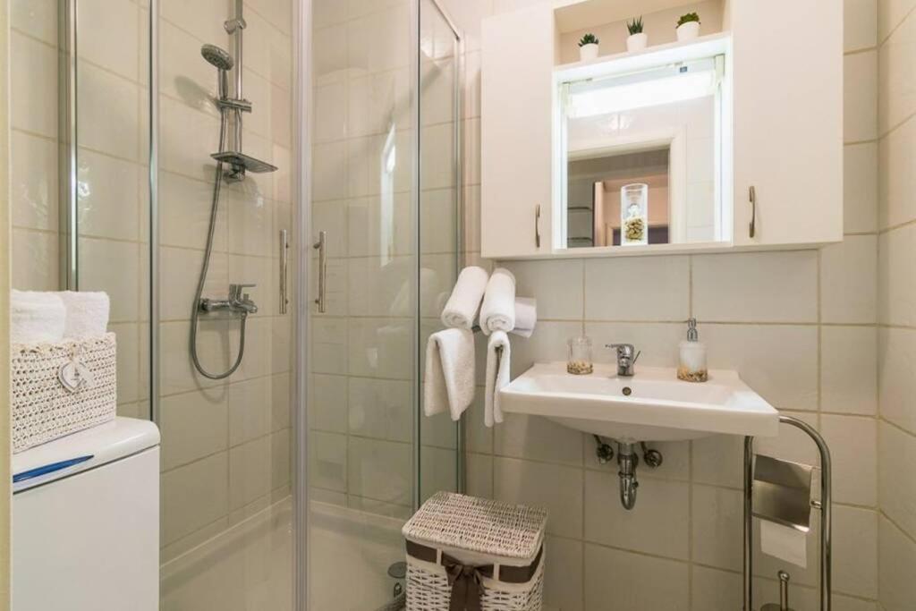 biała łazienka z prysznicem i umywalką w obiekcie Apartment Jarun Brac w Zagrzebiu