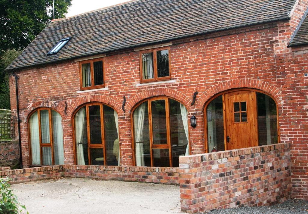 a brick building with large glass windows on it at Haywains Self-Catering at Boningale Manor in Wolverhampton