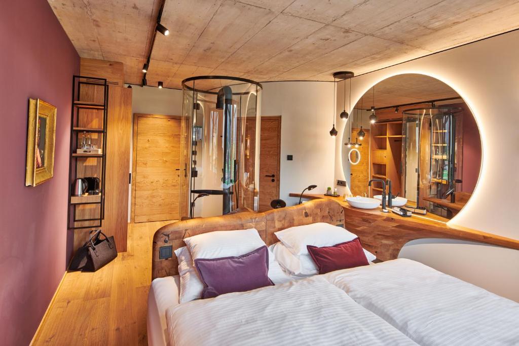 a bedroom with a bed and a mirror at Boutique-Hotel LARTOR in Unterammergau