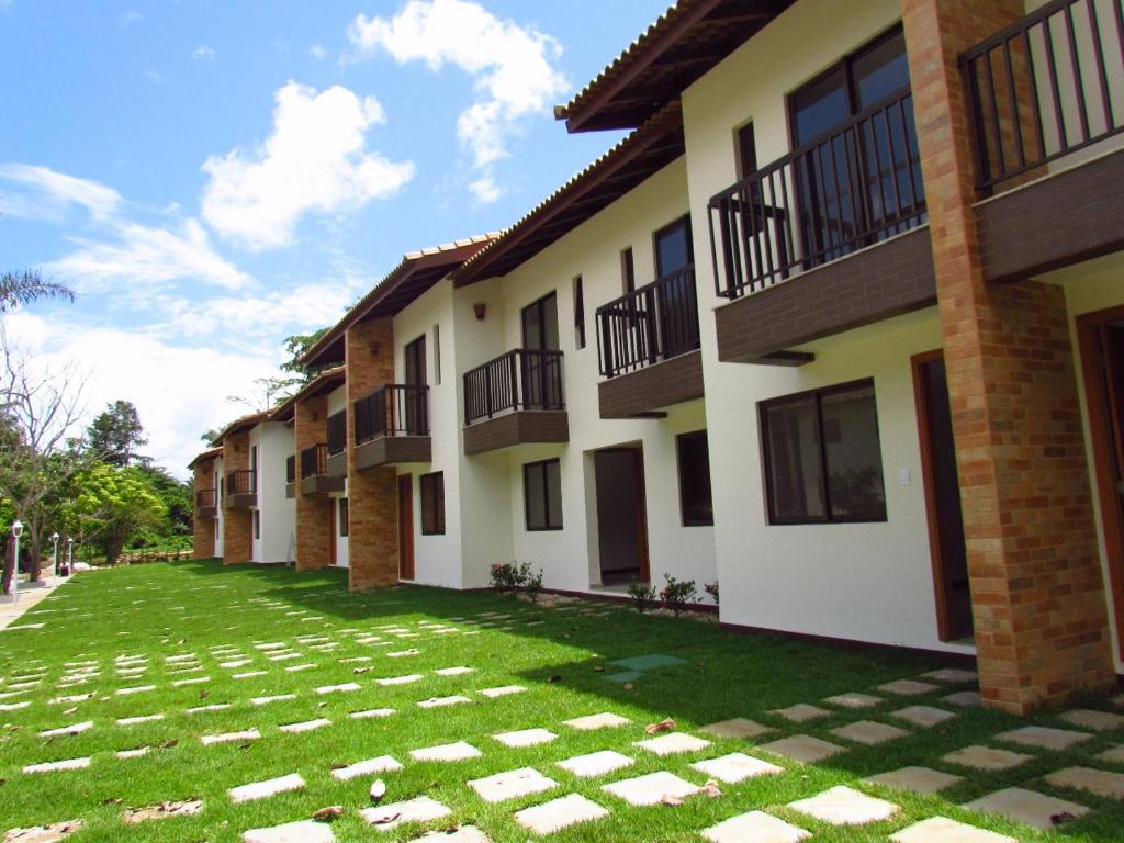 eine Reihe von Apartmentgebäuden mit einem grünen Hof in der Unterkunft Village Angelim in Itacaré