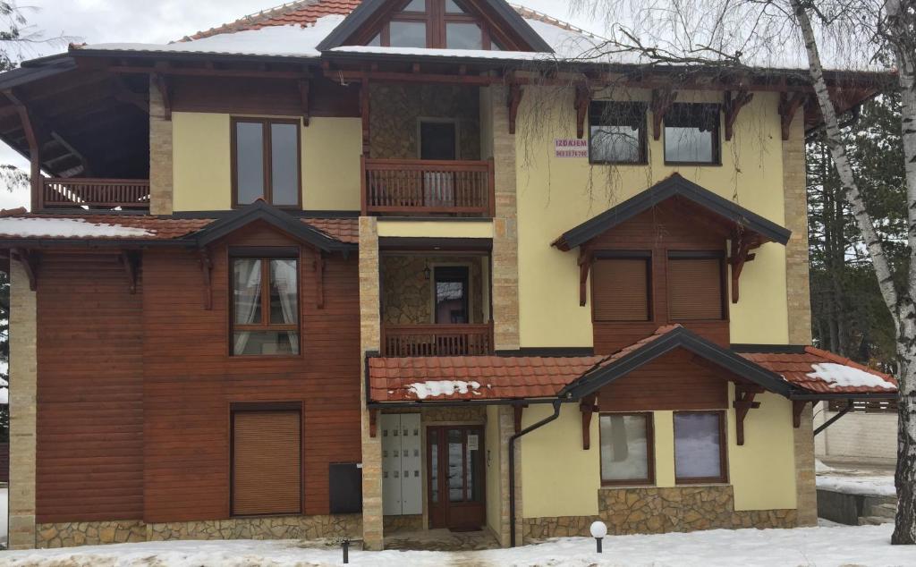 une maison avec de la neige devant elle dans l'établissement Nena apartman, à Zlatibor