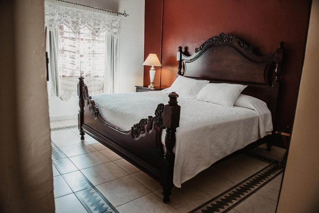 - une chambre avec un grand lit et une tête de lit en bois dans l'établissement TIERRA SOÑADA HOTEL BOUTIQUE, à Tepatitlán de Morelos