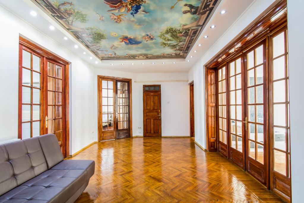 una sala de estar con sofá y una pintura en el techo. en Apartment Faryna, en Bucarest