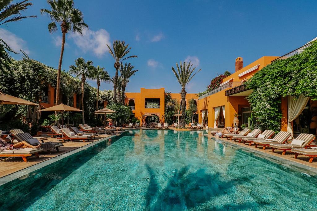 a swimming pool with lounge chairs and a resort at Tikida Golf Palace in Agadir