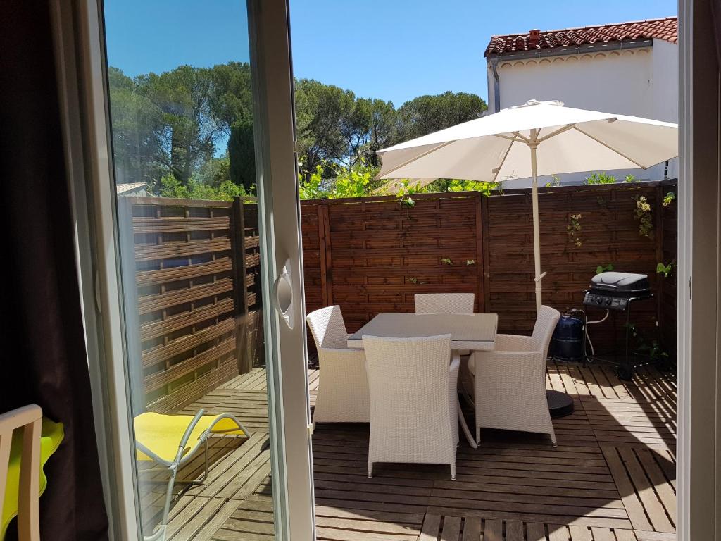 un patio avec une table et un parasol dans l'établissement Résidence Le Clos D'Azur, à Fréjus