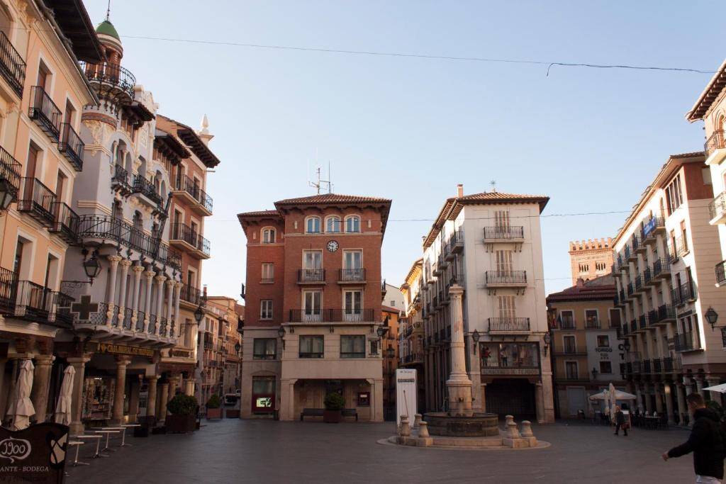 une rue dans une ville avec de grands bâtiments dans l'établissement Sercotel Torico Plaza, à Teruel