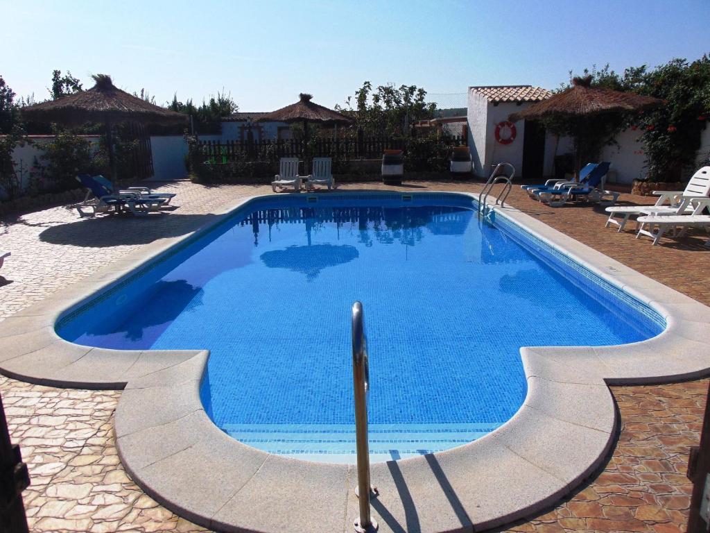 een zwembad met blauw water in een tuin bij El almendro in Barbate