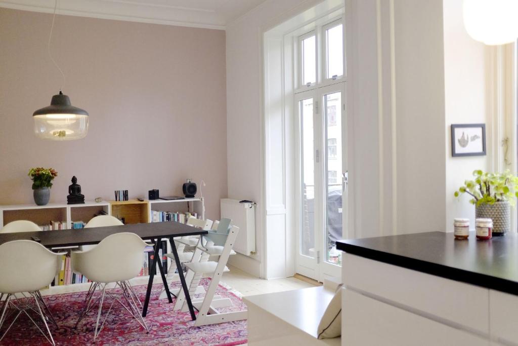 una sala da pranzo con tavolo e sedie bianche di ApartmentInCopenhagen Apartment 1357 a Copenaghen