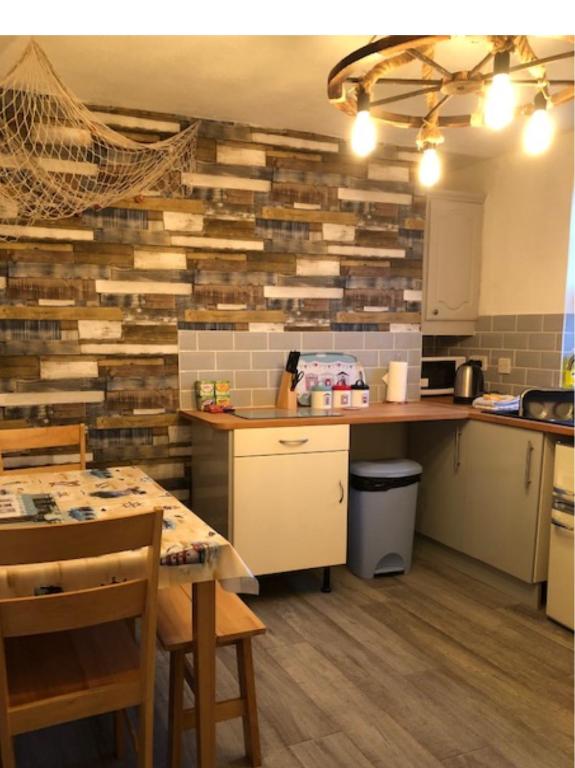 una cocina con una pared hecha de madera regenerada en Fisherman’s Cottage, en Y Felinheli