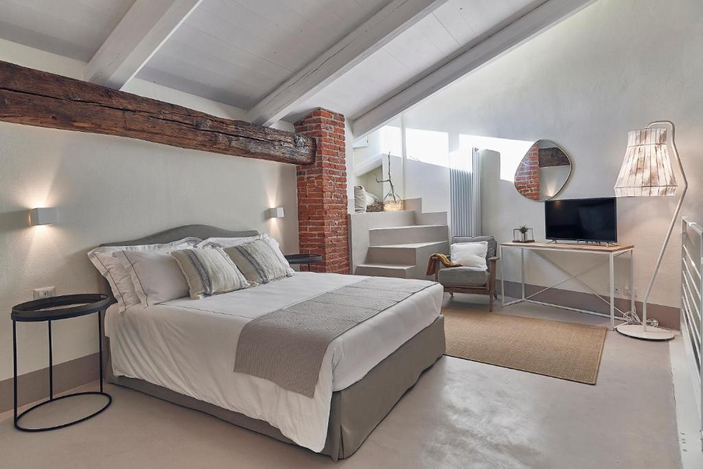 um quarto com uma cama e uma sala de estar em Dora maison de charme em Ivrea