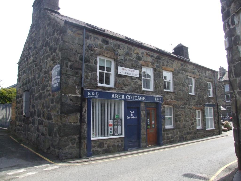 um antigo edifício de pedra ao lado de uma rua em Aber Cottage B&B em Dolgellau