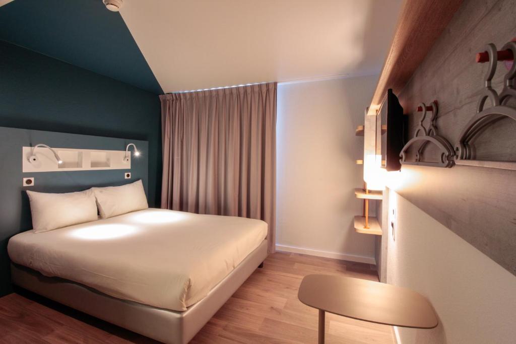 ibis budget Cahors في كاهور: غرفة صغيرة بها سرير وكرسي