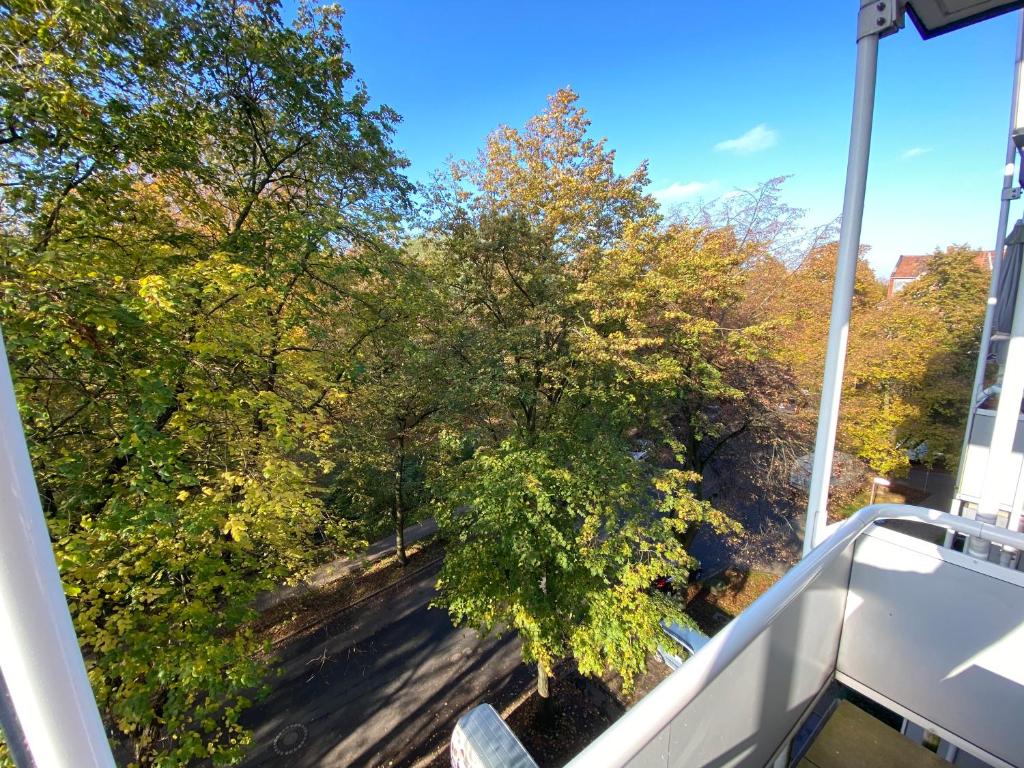 einen Blick auf die Bäume vom Balkon eines Hauses in der Unterkunft Apartment Hannover /Laatzen in Hannover