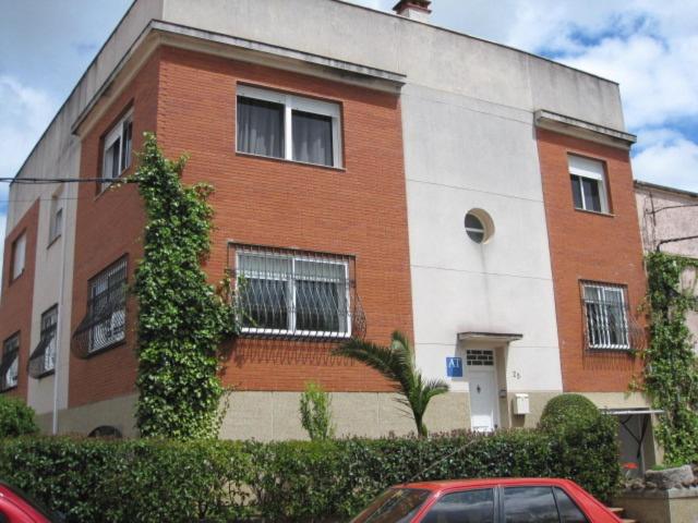 ein Backsteingebäude mit einem davor geparkt in der Unterkunft Apartamento Turístico La Ribera del Marco in Cáceres