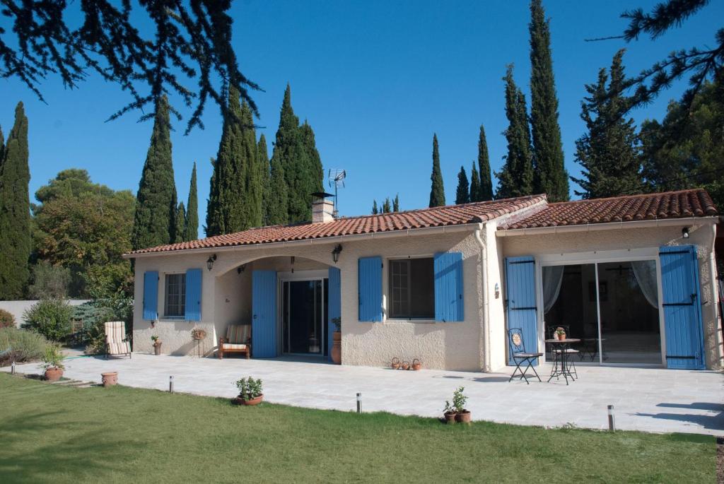 ein kleines Haus mit blauen Türen und einem Hof in der Unterkunft Vintage Provence in Arles