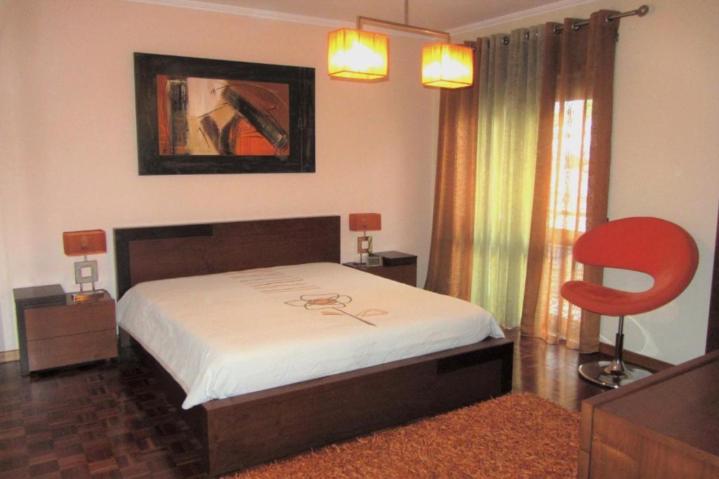 1 dormitorio con 1 cama y 1 silla roja en Apartamento Superior Helena's Porto Corner, en Vila Nova de Gaia