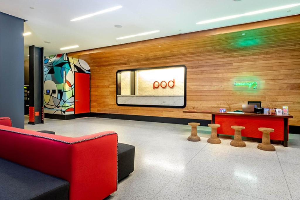 a store lobby with a red couch and a tv at Pod 39 in New York