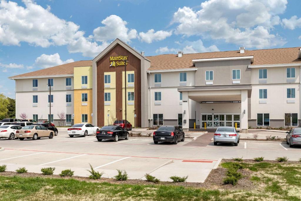 a hotel with cars parked in a parking lot at Sleep Inn Lancaster Dallas South in Lancaster