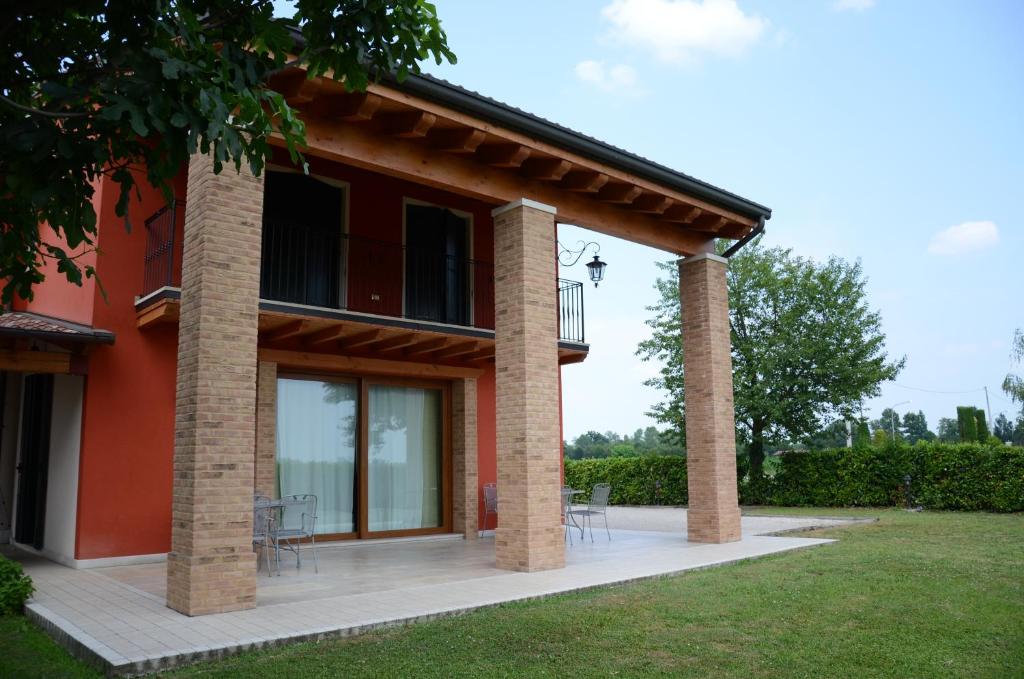 Casa roja con 2 columnas y patio en B&B Al Lauro, en Asolo