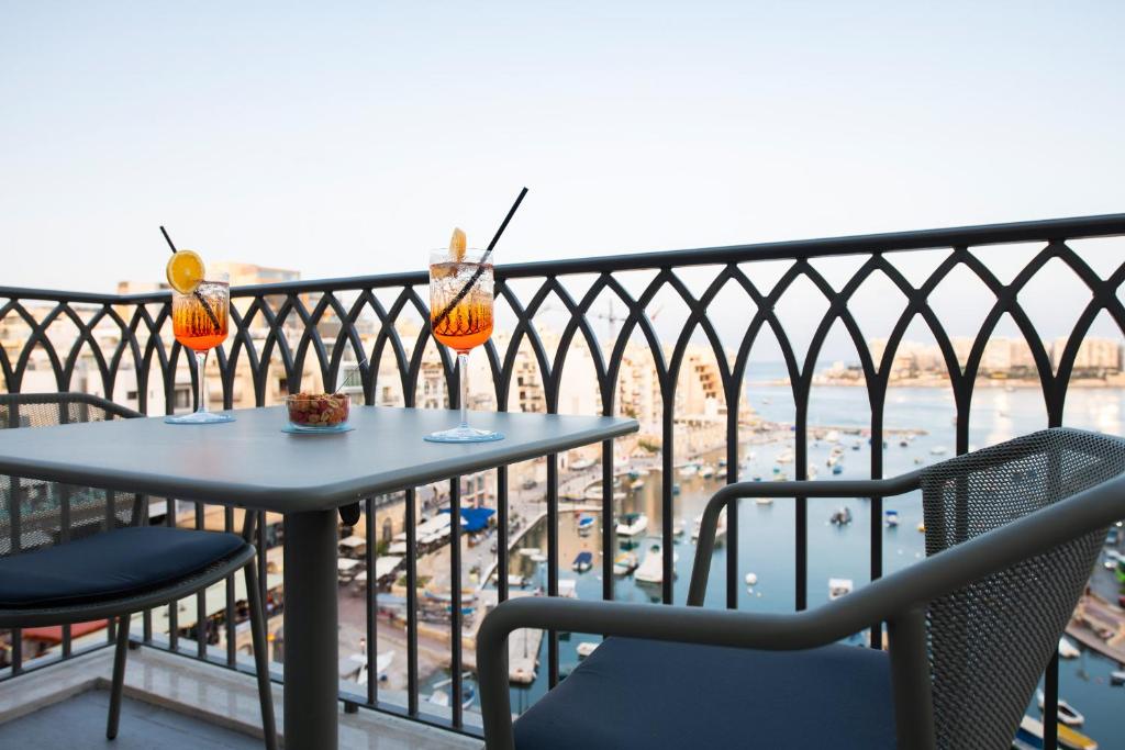 a table and chairs on a balcony with a view at Hotel Juliani - Boutique Hotel in St. Julianʼs