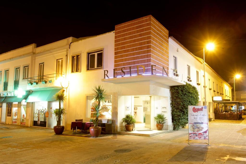 ein Gebäude mit einem Schild in der Nacht davor in der Unterkunft Residencial Mar e Sol in Costa da Caparica