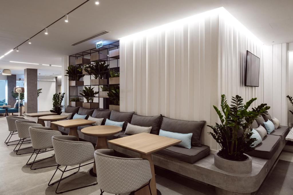 a waiting room with couches and tables and plants at Hotel Juliani - Boutique Hotel in St. Julianʼs