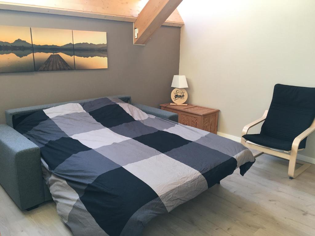 a bedroom with a bed and a chair at Ecolodge Otra Cosa in Mouscron