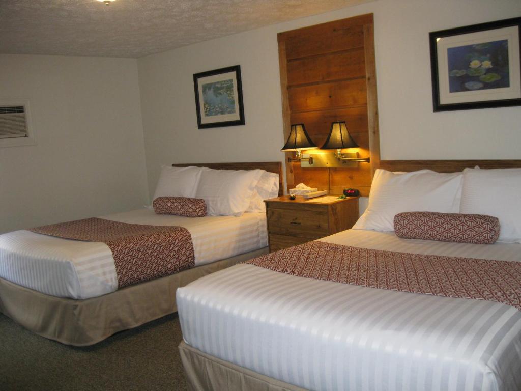 a hotel room with two beds and two lamps at Boyne City Motel in Boyne City