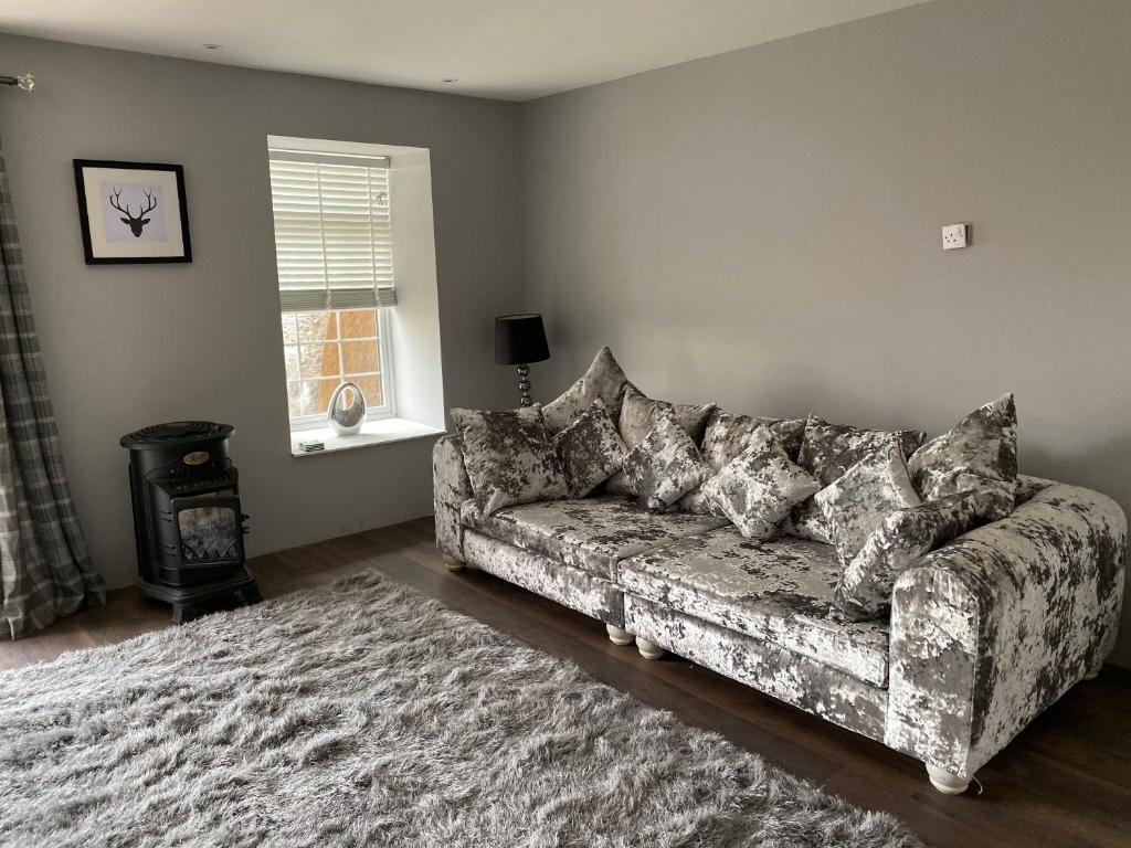 a living room with a couch and a window at COACHMAN COTTAGE OUTSIDE HOT TUB in Beith