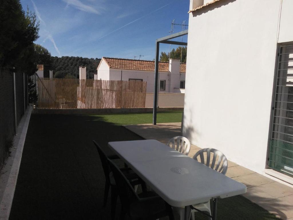a white table and chairs on a patio at Huéznar Rural in San Nicolás del Puerto