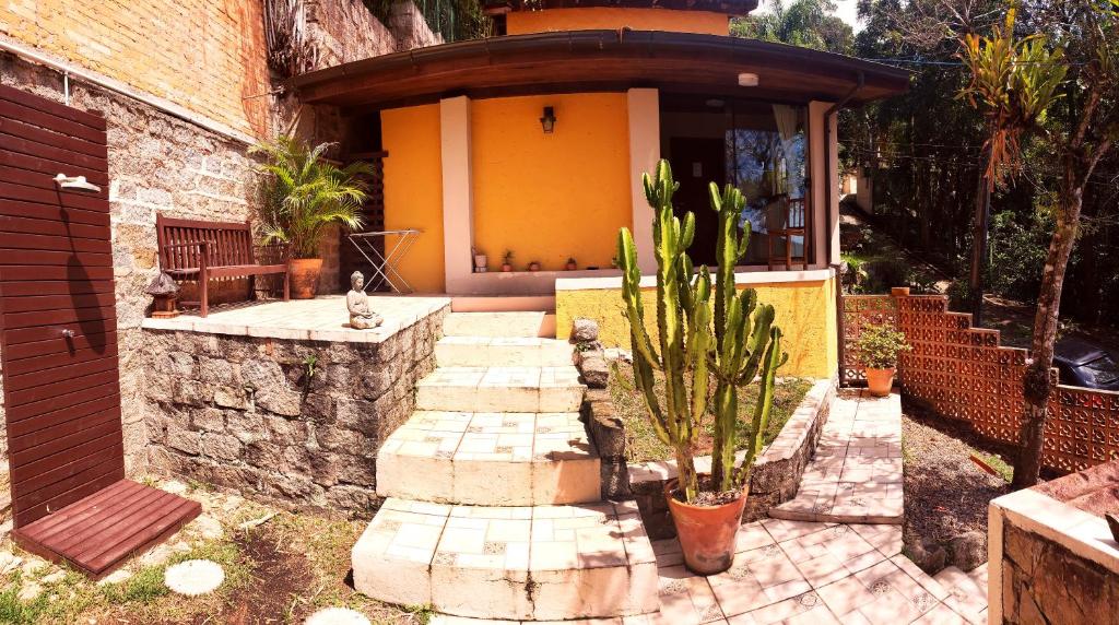 una casa con una pasarela de piedra delante de ella en Plumeria Guest House, en Florianópolis