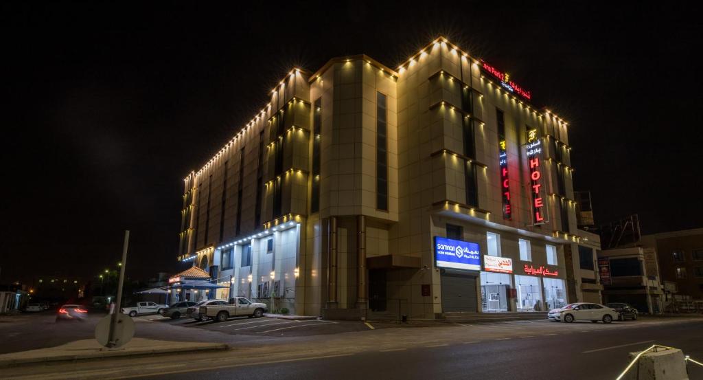 een groot gebouw met 's nachts verlichting bij شقق حديقة الزهور 2 للشقق المخدومة in Yanbu