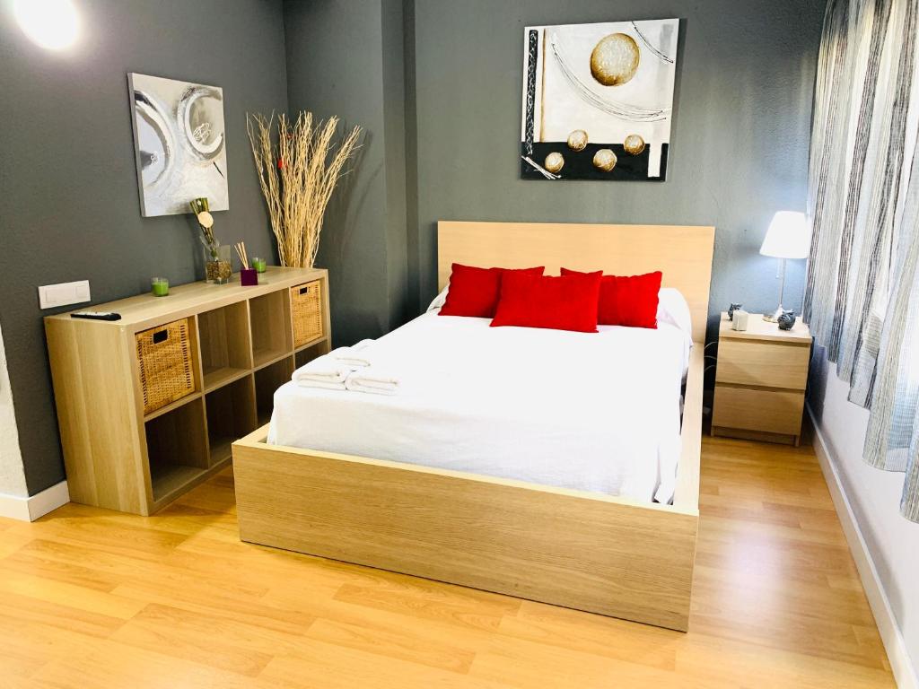 Un dormitorio con una cama con almohadas rojas. en Triana Luxury 113, en Sevilla