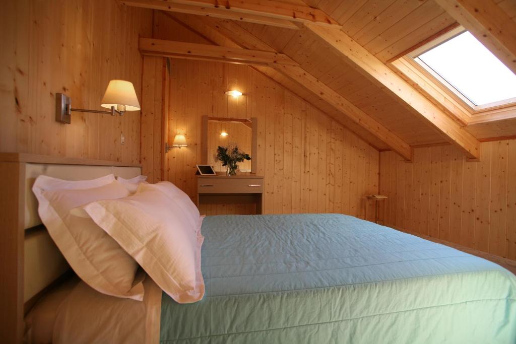 a bedroom with a bed in a room with a window at Grand TheoNi Boutique Hotel & Spa in Vasiliki