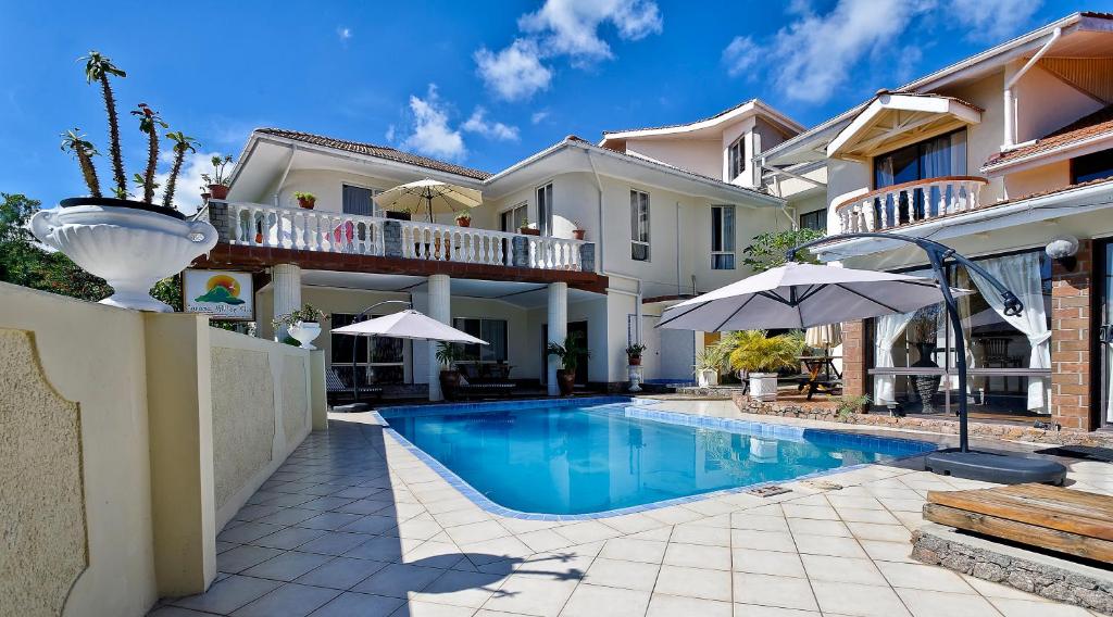 een villa met een zwembad en een huis bij Carana Hilltop Villa in Glacis
